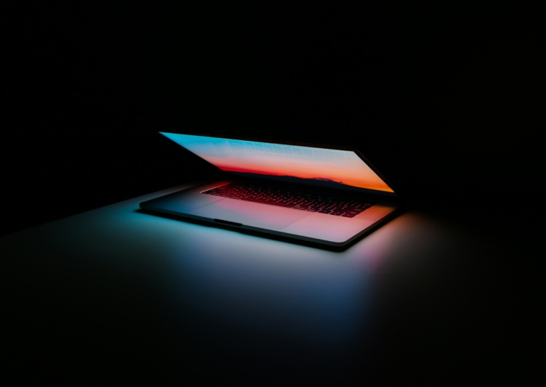 Screen of a laptop illuminating as it closes.